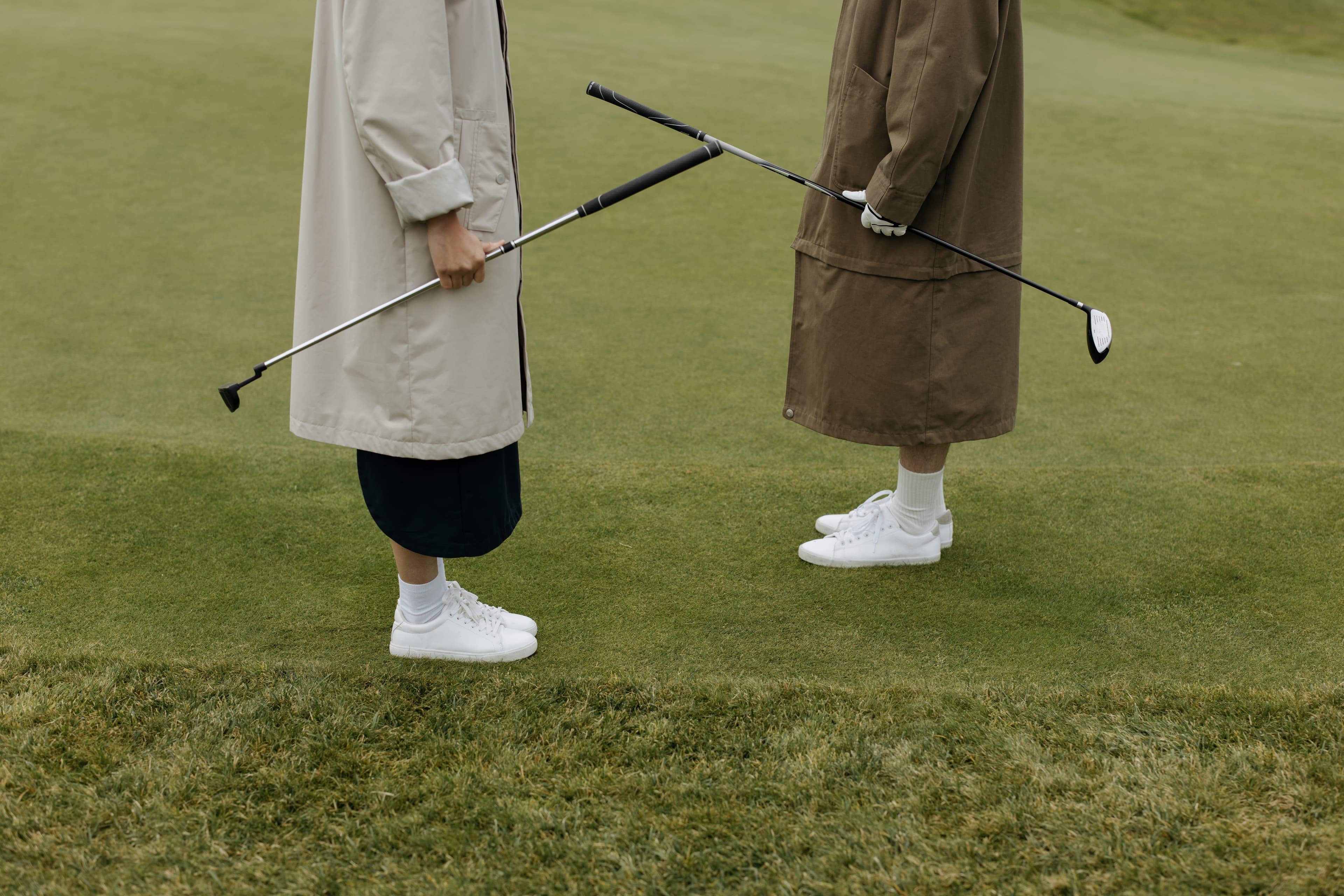 Two golfers crossing clubs on the course